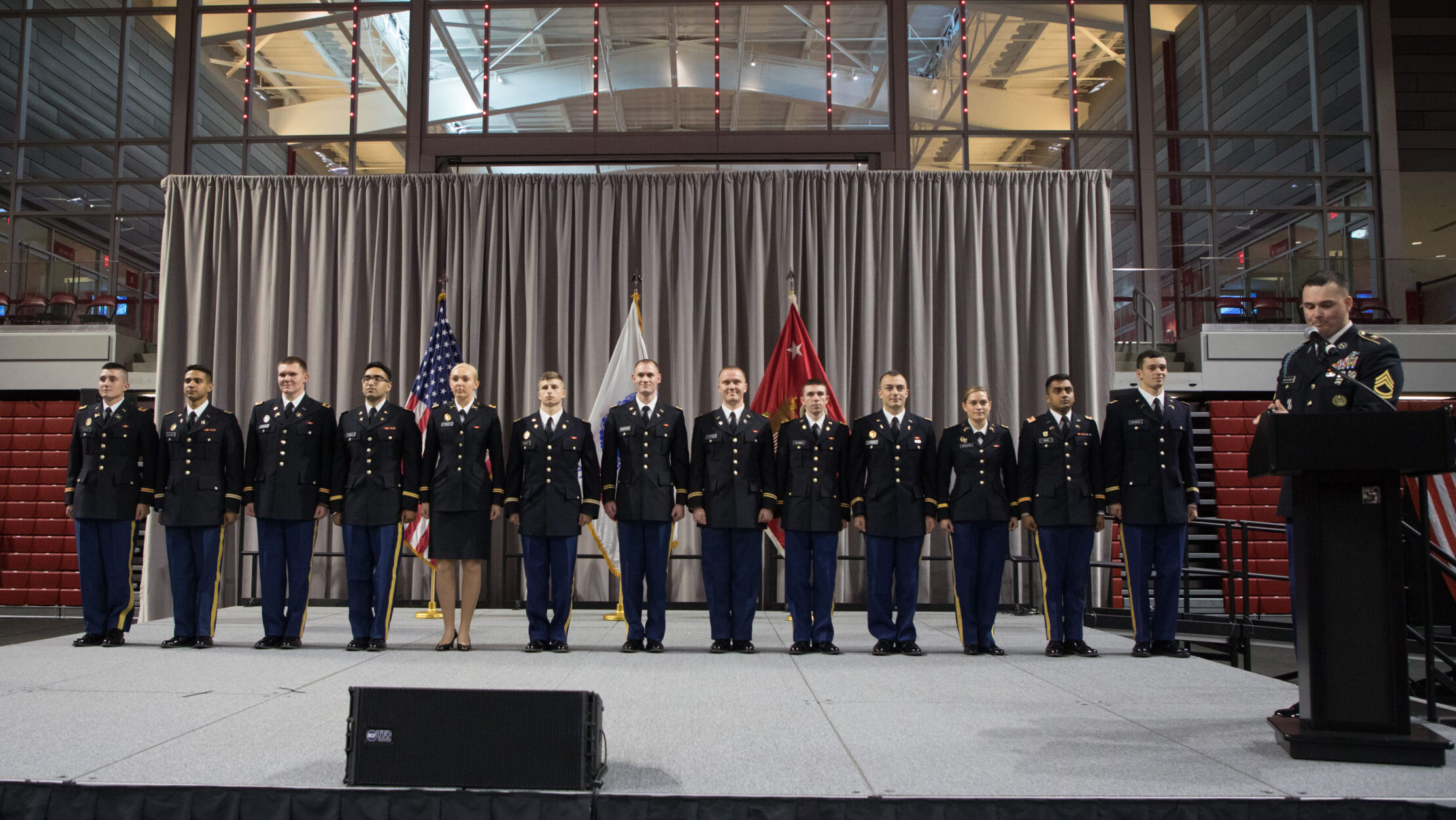 Students stand on stage during the commissioning ceremony