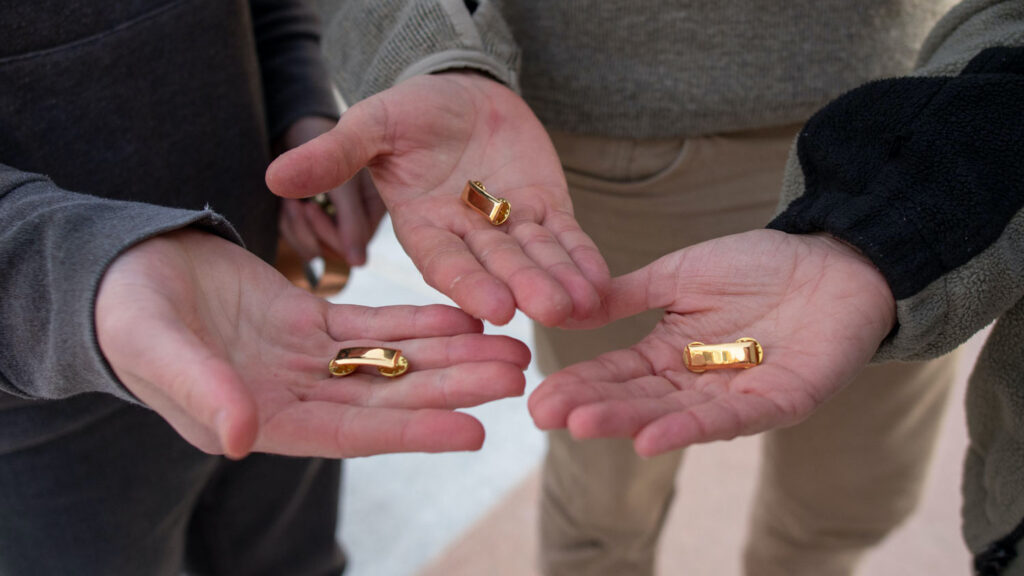 Students hold gold bars in their hands in preparation for the Army ROTC Bar Ceremony